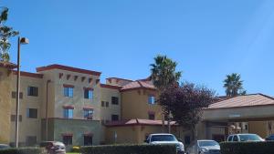 Un edificio con coches aparcados en un estacionamiento. en Best Western Hesperia-Victorville Suites, en Hesperia