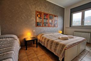 1 dormitorio con 1 cama y 1 mesa con 2 lámparas en Appartamenti La Chiocciola Como - Lipomo, en Como