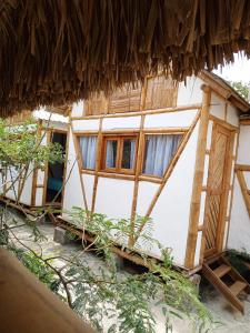 a house with windows and a thatched roof at The Bonito Place in Taganga +7 photos