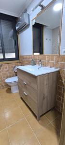 a bathroom with a sink and a toilet and a mirror at Apartamento A Cañiza in La Cañiza +22 photos