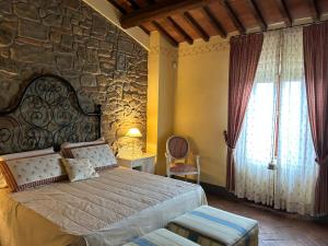 Capraia e LimiteにあるVILLA PANICALE -Toscanaのベッドと石の壁のある寝室 +32枚の写真