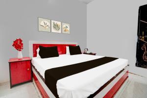 a bedroom with a large bed and a red night stand at Hotel O The King Heaven in Bewar