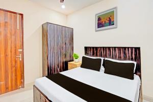 a bedroom with a large bed with a wooden headboard at Hotel O Shree Jee Inn Guest House in Gurgaon