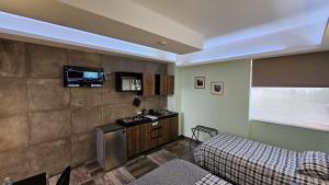 a room with a bed and a tv on the wall at A22 Premium Suite BLACK MAX Cocina Terraza Companies Work Teams 2-4 PAX in Cuautitlán Izcalli
