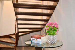 a glass table with a vase of flowers and books at Bursztynowa in Łuków
