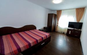 a bedroom with a bed and a flat screen tv at Casa Bibi in 2 Mai