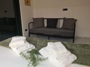 2 toallas en una cama con un sofá en el fondo en Botanica House Krk, en Njivice 36 fotos más