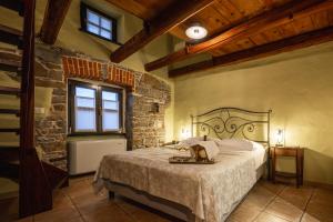 a bedroom with a bed and a stone wall at House Marica in Šmartno