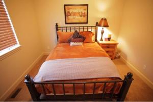 una camera da letto con un letto con lenzuola arancioni e una lampada di 5 bdr 3ba Great House Great Value Resort FUN a Eden