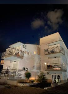 a large white building with two balconies on it at Apartmani AS in Jezera