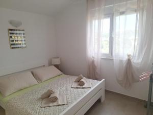 a white bedroom with a bed with towels on it at Apartmani AS in Jezera +39 photos