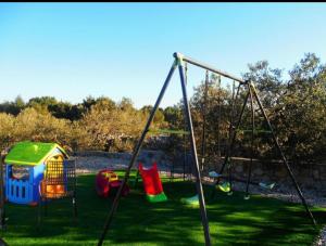 a playground with two swings in the grass at Apartmani AS in Jezera