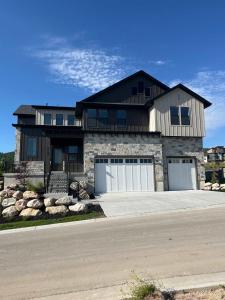 ein großes Haus mit zwei Garagentüren auf einer Straße in der Unterkunft NEW Luxury Home super comfy By Snowbasin & Pow Mow in Huntsville