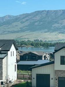 eine Gruppe von Häusern mit einem See und Bergen im Hintergrund in der Unterkunft NEW Luxury Home super comfy By Snowbasin & Pow Mow in Huntsville
