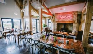 a restaurant with tables and chairs and a fireplace at Willow Warbler - HM112 - Lower Mill Estate Penthouse Apartment with Spa Access in Somerford Keynes