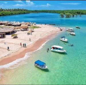 a group of boats in the water on a beach at Bella Morena 1 Ilha de Boipeba in Ilha de Boipeba