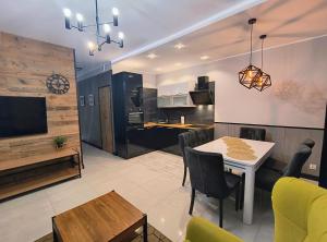 a kitchen and living room with a table and a television at Perła Górska in Szklarska Poręba