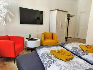 sypialnia z 2 łóżkami, 2 krzesłami i telewizorem w obiekcie Hogulu - im Herzen der Altstadt, Appartement 11 w mieście Brandenburg an der Havel
