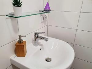 łazienka z białą umywalką i fioletowym stożkiem w obiekcie Hogulu - im Herzen der Altstadt, Appartement 11 w mieście Brandenburg an der Havel