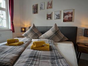 een slaapkamer met een bed met twee gele kussens erop bij Hogulu - STILVOLL UND ZENTRAL - 3-RAUM Appartement 1 in Brandenburg an der Havel