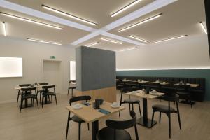 a room with tables and chairs and a projection screen at Hotel am Feldmarksee in Sassenberg