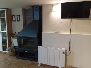 a living room with a fireplace and a television at Casa el Sereno in Salas Bajas