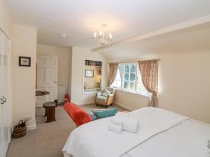 ein Schlafzimmer mit einem weißen Bett und einem Stuhl in der Unterkunft Branklyn Garden Cottage in Perth