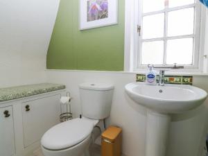 ein Badezimmer mit einer weißen Toilette und einem Waschbecken in der Unterkunft Branklyn Garden Cottage in Perth + 26 Fotos