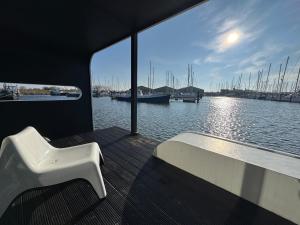 einem weißen Stuhl auf dem Deck eines Bootes in der Unterkunft Wohnboot 'TinyFloat' in Andijk IJsselmeer in Andijk