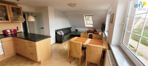 Una cocina y una sala de estar con mesa y sillas. en Fuhrmannshof Ferienwohnung Amke, en Juist