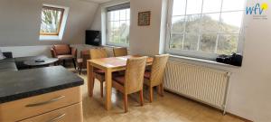 Una cocina y un comedor con mesa y sillas. en Fuhrmannshof Ferienwohnung Amke, en Juist