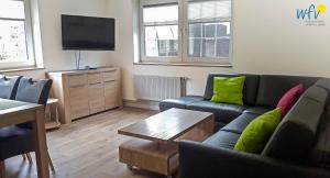 Una sala de estar con un sofá y un televisor. en Fuhrmannshof Ferienwohnung Frauke, en Juist
