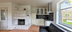 Una sala de estar con chimenea en una cocina. en Fuhrmannshof Ferienwohnung Cassen, en Juist