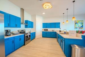 a blue kitchen with white walls and blue cabinets at Indigo Sea Escape in South Padre Island
