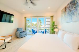 a bedroom with a bed and a chair and a window at Indigo Sea Escape in South Padre Island +19 photos