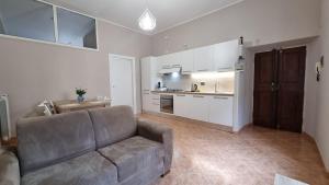a living room with a couch and a kitchen at La Casetta dei Consoli in Castel Madama