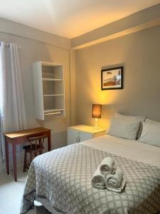 a bedroom with a bed with towels on it at HMG - Praia de Botafogo in Rio de Janeiro