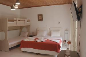 a bedroom with two bunk beds and a red blanket at Kondilw Rooms in Kalamitsi
