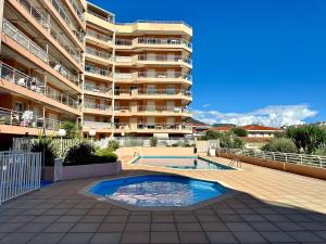 een groot appartementencomplex met een zwembad ervoor bij CAP THALASSA - Beau 2P - Piscine - Parking - AC in Roquebrune-Cap-Martin