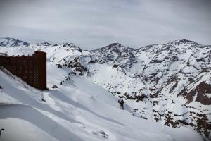 una montaña cubierta de nieve con un edificio en la cima en HOM I Vc1702, en Farellones