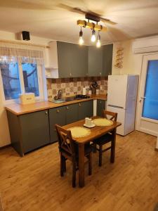 波斯蒂拉Lena的厨房配有木桌、椅子和冰箱