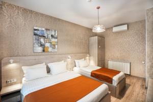 una camera d'albergo con due letti e un lampadario a braccio di 1 Hotel Borjomi a Borjomi