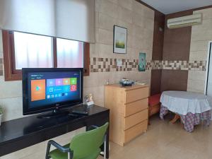 a room with a tv and a table with a chair at Comfy Studio in the Countryside Bonito y grande Estudio in Alhaurín de la Torre