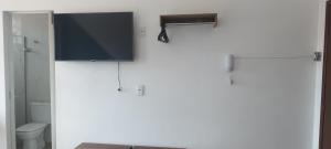 a bathroom with a tv on a white wall at Suites Duarte - Centro Histórico in Ouro Preto