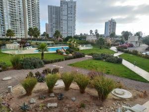 a garden with a swimming pool in a city at Hermoso departamento en Serena a pasos de la playa y casino in Coquimbo