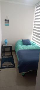 a bedroom with a bed and a table and a window at Hermoso departamento en Serena a pasos de la playa y casino in Coquimbo