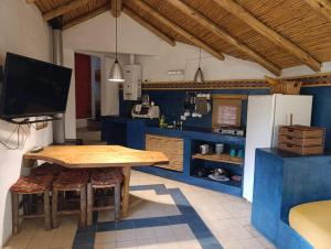 Una cocina con una mesa de madera y un refrigerador. en Posada La Valentina, en Villa Las Rosas