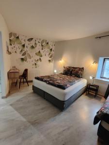 a bedroom with a bed in the corner of a room at La ferme aux chats in Formigny