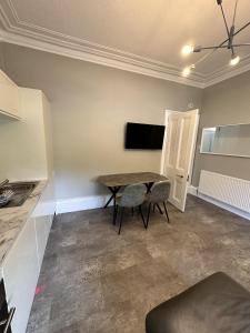 Una cocina con una mesa y sillas en una habitación. en Springbank Apartment, en Aberdeen