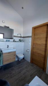 翁特拉梅尔高Oberland-Ferienwohnung-Ammertal-Wurmansau-inkl-Koenigscard的一间带卫生间和水槽的浴室以及一扇木门。